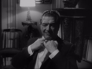 Movie still from “The Exterminating Angel” (1962), directed by Luis Buñuel – A black and white photo of a man adjusting his tie; Close Up shot, Low angle