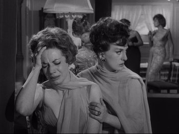 Movie still from “The Exterminating Angel” (1962), directed by Luis Buñuel – A couple of women standing next to each other; Medium shot, Over the shoulder angle
