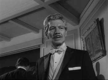 Movie still from “The Exterminating Angel” (1962), directed by Luis Buñuel – An older man wearing a suit and bow tie; Close Up shot, Low angle