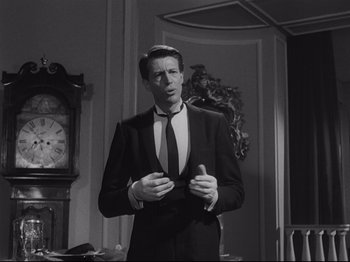 Movie still from “The Exterminating Angel” (1962), directed by Luis Buñuel – A black and white photo of a man in a suit and tie; Medium shot, Low angle