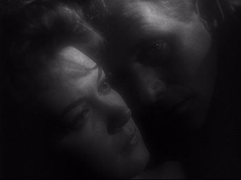 Movie still from “The Exterminating Angel” (1962), directed by Luis Buñuel – A man and a woman face to face in the dark; Close Up shot, High angle