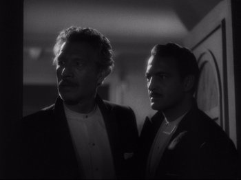 Movie still from “The Exterminating Angel” (1962), directed by Luis Buñuel – A black and white photo of two men standing next to each other; Close Up shot, Low angle