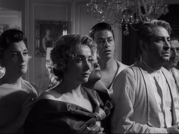 Movie still from “The Exterminating Angel” (1962), directed by Luis Buñuel – A group of people standing in a room; Medium shot, Low angle