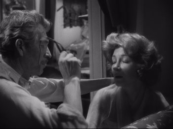 Movie still from “The Exterminating Angel” (1962), directed by Luis Buñuel – An older man and a younger woman are looking at each other in the mirror; Close Up shot, Over the shoulder angle
