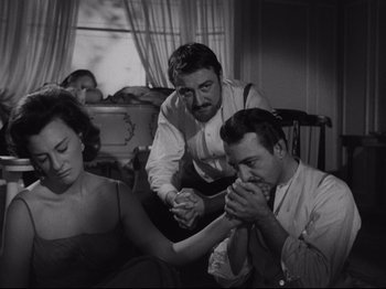 Movie still from “The Exterminating Angel” (1962), directed by Luis Buñuel – A group of people that are sitting in a living room; Medium shot, High angle