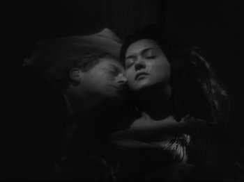 Movie still from “The Exterminating Angel” (1962), directed by Luis Buñuel – A man and a woman sleeping next to each other; Close Up shot, Overhead angle