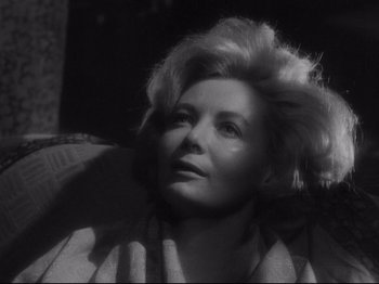 Movie still from “The Exterminating Angel” (1962), directed by Luis Buñuel – An older woman with blonde hair sitting on a chair; Close Up shot, Low angle