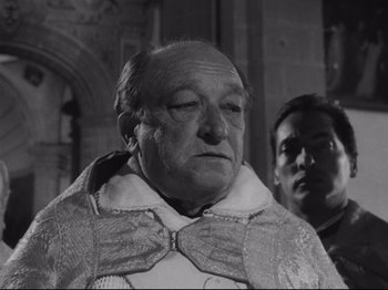 Movie still from “The Exterminating Angel” (1962), directed by Luis Buñuel – An old man wearing a priest's outfit and a priest's collar; Close Up shot, Low angle