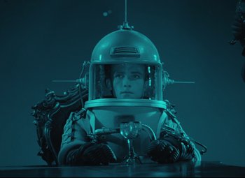 Movie still from “The Fabulous Baron Munchausen” (1962), directed by Karel Zeman – A man in a space suit sitting at a table with a glass of wine; Medium shot, High angle
