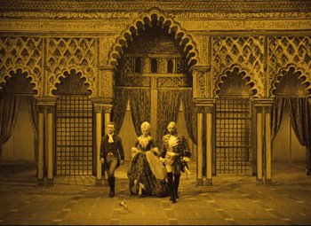 Movie still from “The Fabulous Baron Munchausen” (1962), directed by Karel Zeman – A scene of a stage with a man and a woman and a man; Extreme Wide shot, High angle