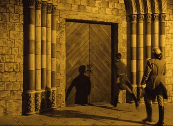 Movie still from “The Fabulous Baron Munchausen” (1962), directed by Karel Zeman – Two people are walking in front of an open door; Extreme Wide shot, High angle