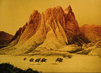 Movie still from “The Fabulous Baron Munchausen” (1962), directed by Karel Zeman – A group of people riding horses in the desert; Extreme Wide shot, Low angle