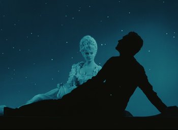 Movie still from “The Fabulous Baron Munchausen” (1962), directed by Karel Zeman – A man and a woman sitting on the ground in front of a star filled sky; Wide shot, Low angle