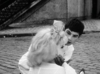 Movie still from “The Fiancés of the Bridge Mac Donald” (1961), directed by Agnès Varda – A man and a woman sitting on the ground; Close Up shot, High angle