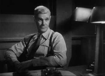 Movie still from “The File on Thelma Jordon” (1949), directed by Robert Siodmak – An older man sitting at a table in a room; Medium shot, Low angle