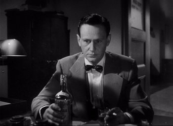 Movie still from “The File on Thelma Jordon” (1949), directed by Robert Siodmak – A black and white photo of a man holding a bottle of alcohol; Close Up shot, Low angle