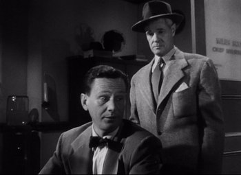 Movie still from “The File on Thelma Jordon” (1949), directed by Robert Siodmak – A man in a suit and tie next to another man in a suit and tie; Medium shot, Low angle