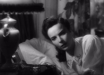 Movie still from “The File on Thelma Jordon” (1949), directed by Robert Siodmak – A black - and - white photo of a woman sitting in front of a lamp; Close Up shot, High angle