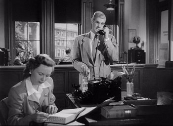 Movie still from “The File on Thelma Jordon” (1949), directed by Robert Siodmak – A man and a woman are sitting at a desk; Medium shot, Low angle