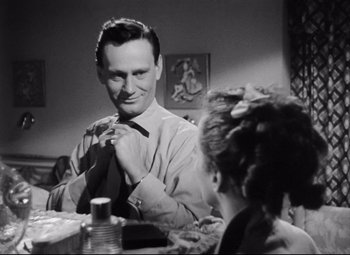 Movie still from “The File on Thelma Jordon” (1949), directed by Robert Siodmak – A black and white photo of a man adjusting his tie; Close Up shot, Over the shoulder angle