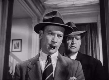 Movie still from “The File on Thelma Jordon” (1949), directed by Robert Siodmak – Two men in suits and hats are smoking a cigarette; Close Up shot, Low angle