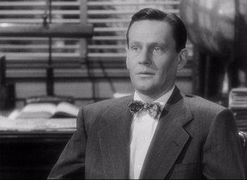 Movie still from “The File on Thelma Jordon” (1949), directed by Robert Siodmak – A black and white photo of a man wearing a suit and bow tie; Close Up shot, Low angle