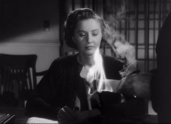 Movie still from “The File on Thelma Jordon” (1949), directed by Robert Siodmak – A black and white photo of a woman lighting a candle; Close Up shot, High angle