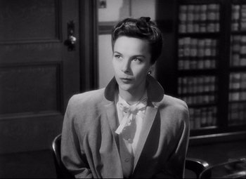 Movie still from “The File on Thelma Jordon” (1949), directed by Robert Siodmak – A black and white photo of a woman in a suit and tie; Close Up shot, Low angle