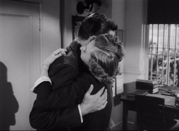 Movie still from “The File on Thelma Jordon” (1949), directed by Robert Siodmak – A man and a woman hugging each other in a living room; Medium shot, Low angle