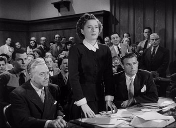 Movie still from “The File on Thelma Jordon” (1949), directed by Robert Siodmak – An old photo of a woman standing in front of a crowd; Medium shot, High angle