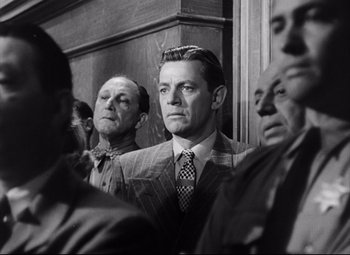 Movie still from “The File on Thelma Jordon” (1949), directed by Robert Siodmak – Black and white photograph of men in suits and ties; Medium shot, Low angle