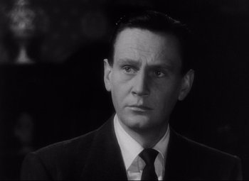 Movie still from “The File on Thelma Jordon” (1949), directed by Robert Siodmak – A man wearing a suit and tie in a black and white photo; Close Up shot, Low angle
