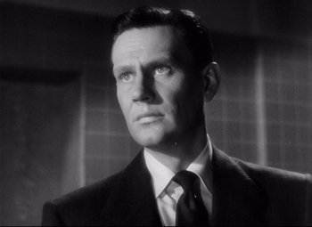 Movie still from “The File on Thelma Jordon” (1949), directed by Robert Siodmak – A man wearing a suit and tie in a black and white photo; Close Up shot, Low angle
