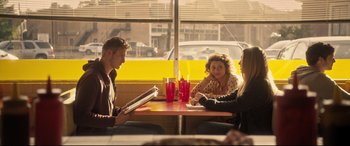 Movie still from “The Final Girls” (2015), directed by Todd Strauss-Schulson – A group of people sitting at a table in front of a window; Wide shot, Over the shoulder angle