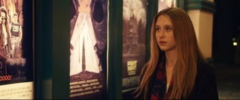 Movie still from “The Final Girls” (2015), directed by Todd Strauss-Schulson – A woman standing in front of a movie poster; Close Up shot, Over the shoulder angle