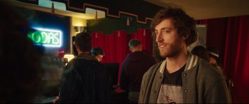 Movie still from “The Final Girls” (2015), directed by Todd Strauss-Schulson – A man standing in front of a group of people; Medium shot, Over the shoulder angle
