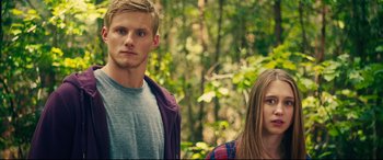 Movie still from “The Final Girls” (2015), directed by Todd Strauss-Schulson – A man and a woman standing next to each other in the woods; Medium shot, Low angle