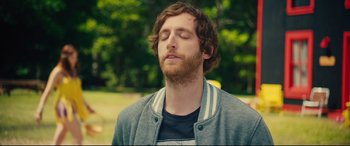 Movie still from “The Final Girls” (2015), directed by Todd Strauss-Schulson – A man with a beard is meditating in the park; Close Up shot, Over the shoulder angle