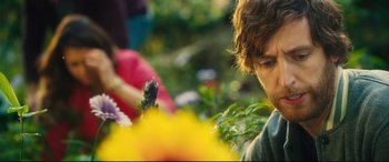 Movie still from “The Final Girls” (2015), directed by Todd Strauss-Schulson – A man looking at a flower in a garden; Close Up shot, Over the shoulder angle