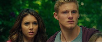 Movie still from “The Final Girls” (2015), directed by Todd Strauss-Schulson – A man and a woman standing next to each other in front of trees; Close Up shot, High angle