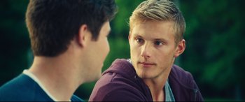 Movie still from “The Final Girls” (2015), directed by Todd Strauss-Schulson – Two young men talking to each other in a park setting; Close Up shot, Over the shoulder angle