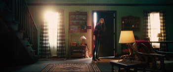 Movie still from “The Final Girls” (2015), directed by Todd Strauss-Schulson – A person standing in a room with a guitar; Wide shot, Low angle