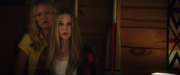 Movie still from “The Final Girls” (2015), directed by Todd Strauss-Schulson – A girl with long blonde hair wearing a red and black plaid shirt; Close Up shot, Over the shoulder angle