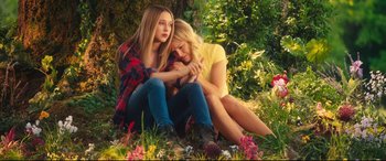 Movie still from “The Final Girls” (2015), directed by Todd Strauss-Schulson – Two women sitting on the ground in the grass; Medium shot, High angle