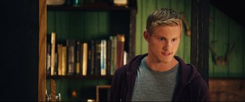 Movie still from “The Final Girls” (2015), directed by Todd Strauss-Schulson – A man with blonde hair and a gray shirt; Close Up shot, Over the shoulder angle