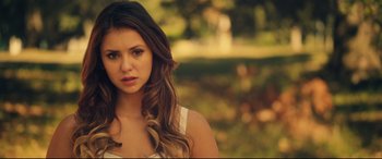 Movie still from “The Final Girls” (2015), directed by Todd Strauss-Schulson – A beautiful young lady standing in front of a forest; Close Up shot, Over the shoulder angle