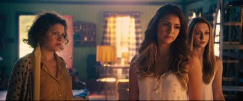 Movie still from “The Final Girls” (2015), directed by Todd Strauss-Schulson – A beautiful young woman standing in a living room; Close Up shot, Over the shoulder angle