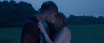 Movie still from “The Final Girls” (2015), directed by Todd Strauss-Schulson – A man and a woman kissing in a field at night; Medium shot, Over the shoulder angle