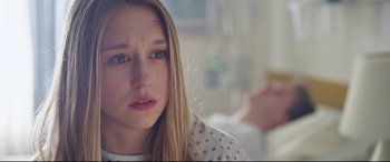 Movie still from “The Final Girls” (2015), directed by Todd Strauss-Schulson – A young girl is sitting in front of the camera; Close Up shot, Over the shoulder angle