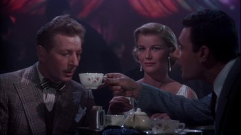 Movie still from “The Five Pennies” (1959), directed by Melville Shavelson – A man and two women sitting at a table with a cup of tea; Medium shot, Low angle